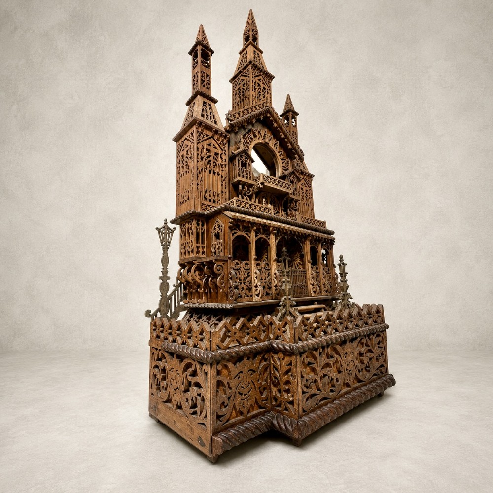 A carved wooden clock case designed in a Gothic cathedral architectural style with detailed fretwork, three spires, and a circular central opening. View IV
