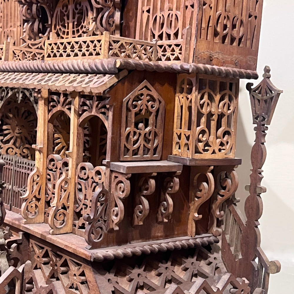 A carved wooden clock case designed in a Gothic cathedral architectural style with detailed fretwork, three spires, and a circular central opening. View VIII