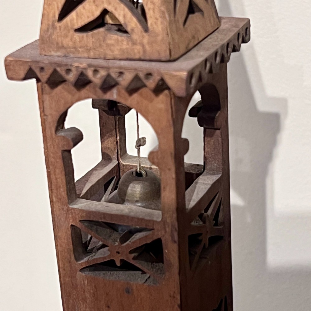 A carved wooden clock case designed in a Gothic cathedral architectural style with detailed fretwork, three spires, and a circular central opening. View IX