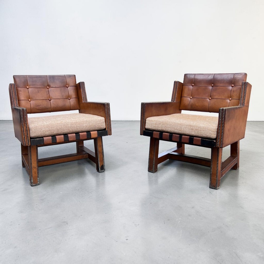 A pair of French 1930s cognac leather button-back armchairs with brass stud detailing and fabric seat cushions on wooden frames. View II
