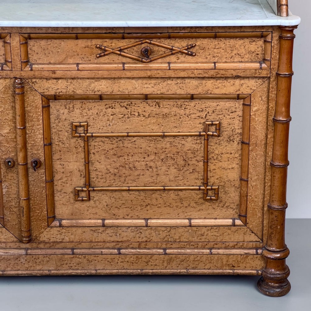Late 19th-century French faux-bamboo birds-eye maple washstand featuring a central mirror, side shelf tiers, marble splashback and surface, over two drawers and a double cupboard. View X