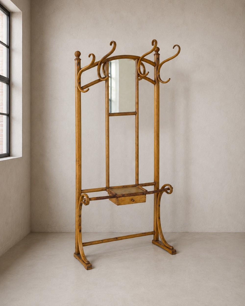 A tall steam-bent beechwood hall stand with a warm honey finish, featuring top coat hooks, a central rectangular mirror, a small drawer, and a lower umbrella rail.