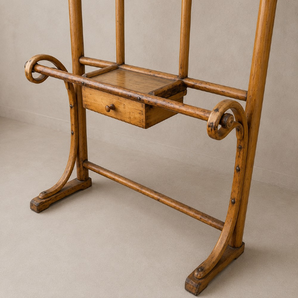 A tall steam-bent beechwood hall stand with a warm honey finish, featuring top coat hooks, a central rectangular mirror, a small drawer, and a lower umbrella rail. View V