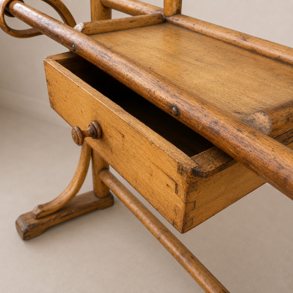 A tall steam-bent beechwood hall stand with a warm honey finish, featuring top coat hooks, a central rectangular mirror, a small drawer, and a lower umbrella rail. View VI