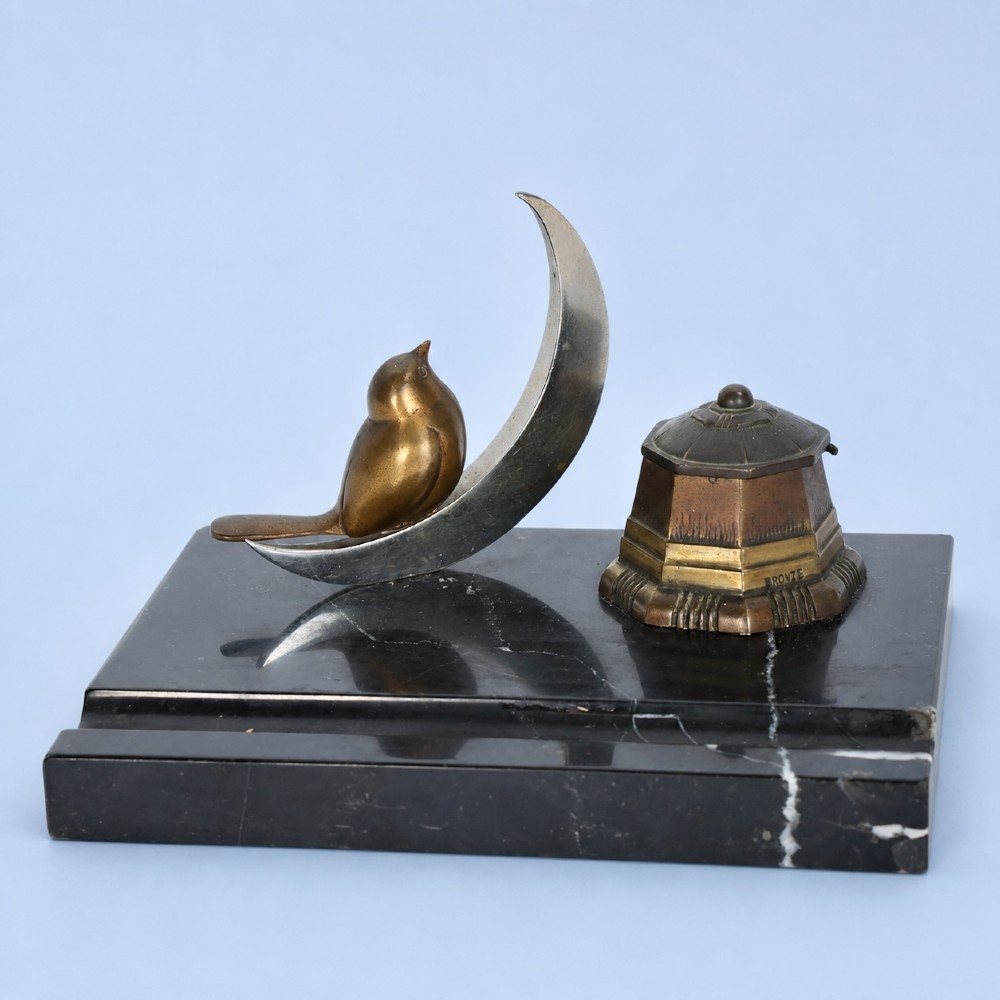 An Art Deco black marble desk tidy featuring a bronze bird perched on a silver-coloured crescent moon beside an octagonal metal inkwell. View II