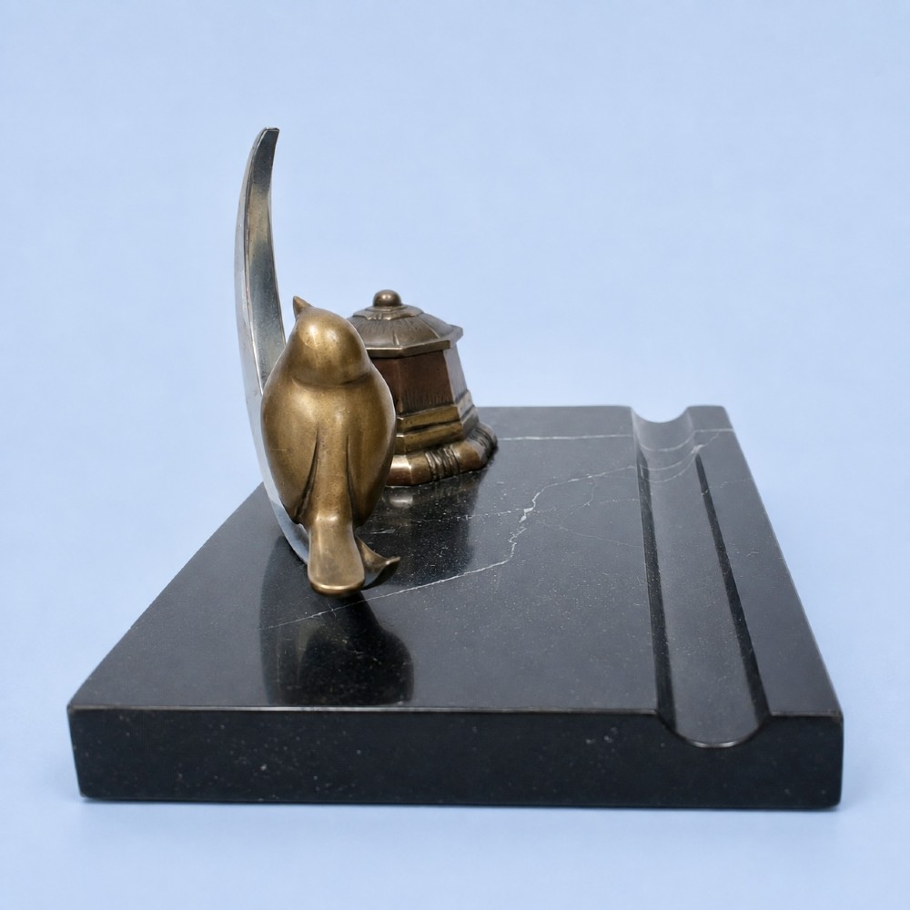 An Art Deco black marble desk tidy featuring a bronze bird perched on a silver-coloured crescent moon beside an octagonal metal inkwell. View IV