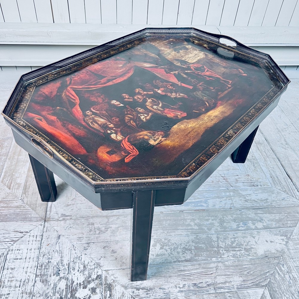 A nineteenth-century octagonal painted metal toleware tray table featuring a classical scene depicting the family of Darius before Alexander, set upon a dark wooden base. View II
