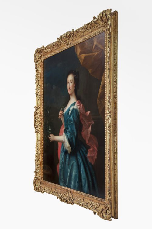 fig 2. An 18th-century oil painting depicting a woman in a blue satin dress beside a potted orange tree, framed in carved giltwood.