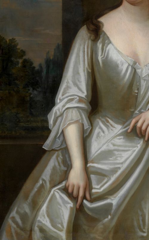 fig 7. A portrait depicting a woman in a silver satin dress seated next to draped red fabric, enclosed within an ornate carved gold frame.