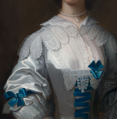 fig 4. A half-length mid-18th-century oil portrait of a lady wearing a white lace-trimmed silk gown decorated with blue ribbons, set within a carved giltwood frame.