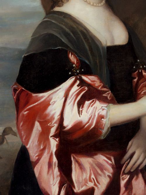 fig 3. A seventeenth-century oil portrait of a lady wearing a black dress with red satin sleeves and pearls, housed in a carved gilded frame.