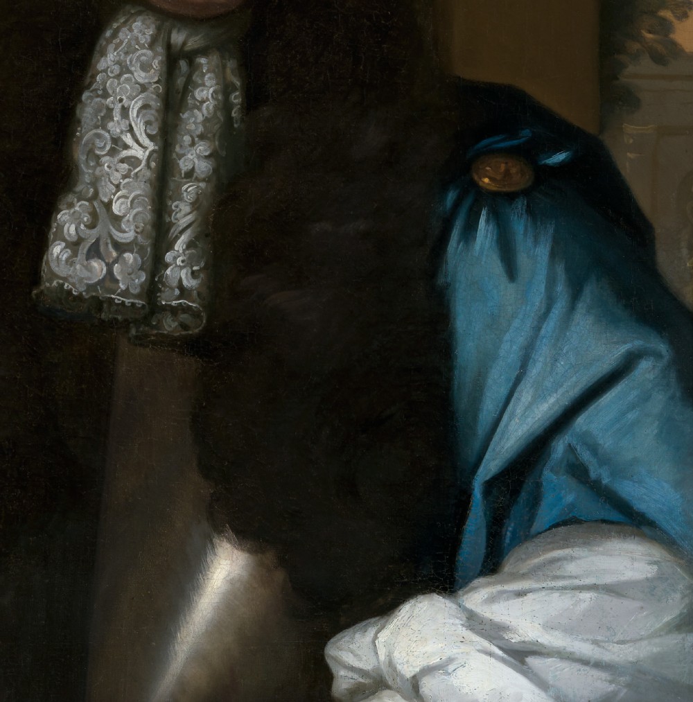 An oil portrait depicting a gentleman in a long dark wig, lace cravat, and blue cloak, presented within an ornate carved giltwood frame. View VIII