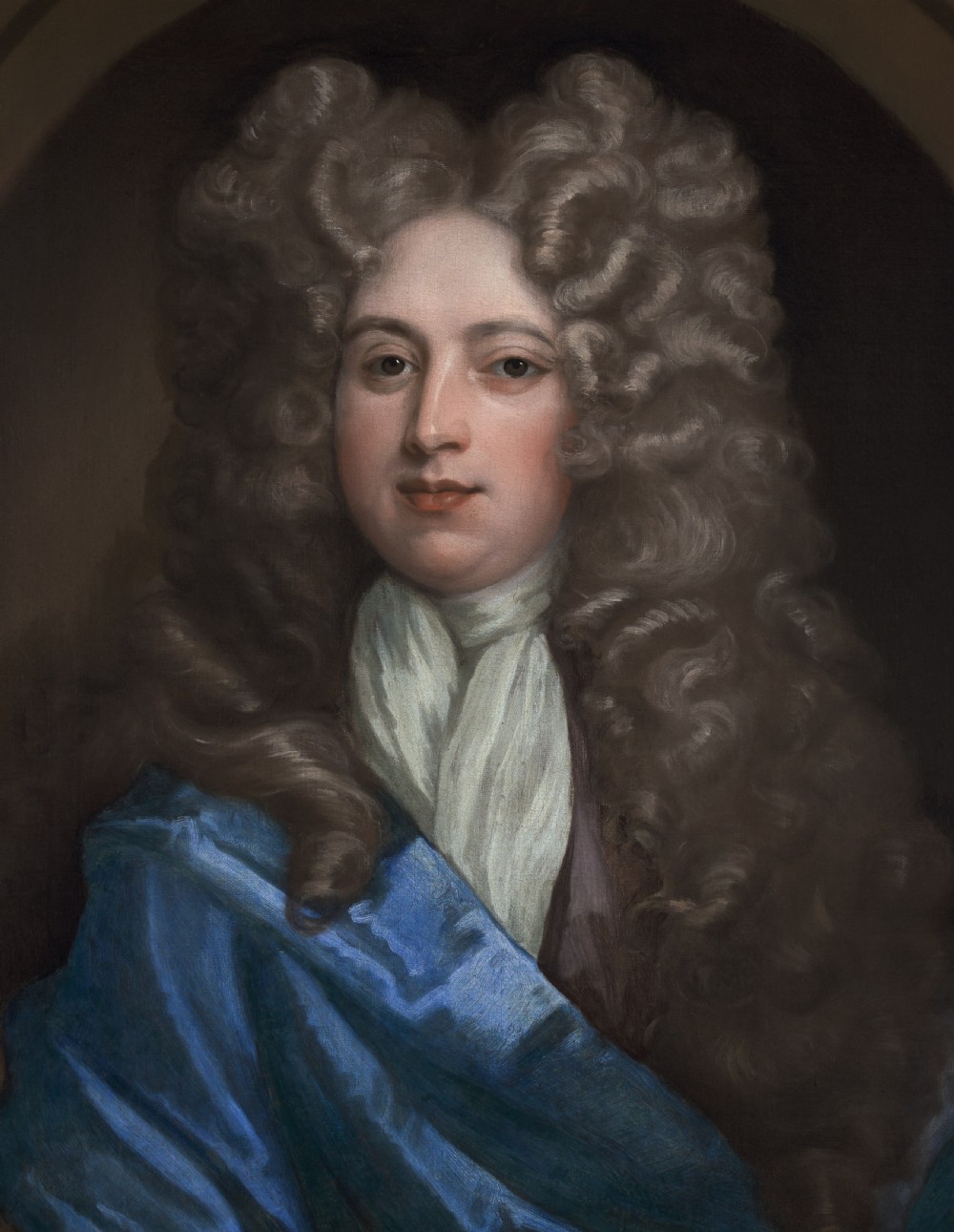 An oil on canvas portrait depicting a gentleman in a full brown periwig and draped blue cloak set within an oval spandrel and carved gold frame. View V