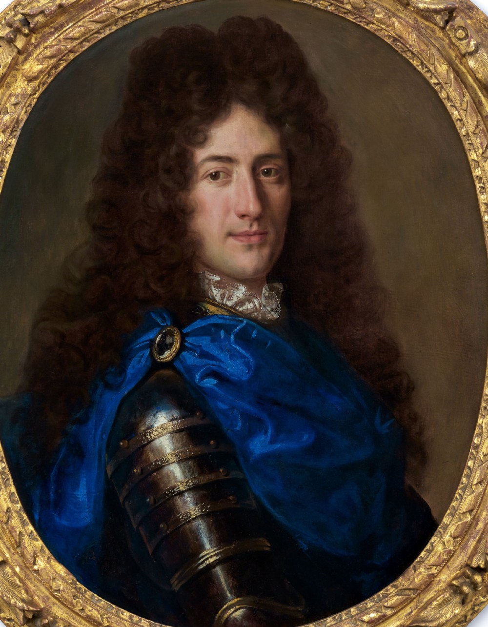 An oval oil painting depicting a gentleman wearing plate armour and an azure blue cloak with a jewelled brooch, set within a carved gold gilt frame. View II
