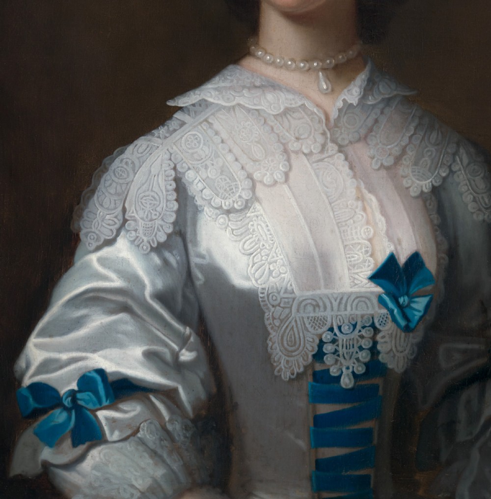 An 18th-century oil portrait depicting a lady in a white silk dress adorned with blue ribbons, housed within a ornate gilded frame. View V