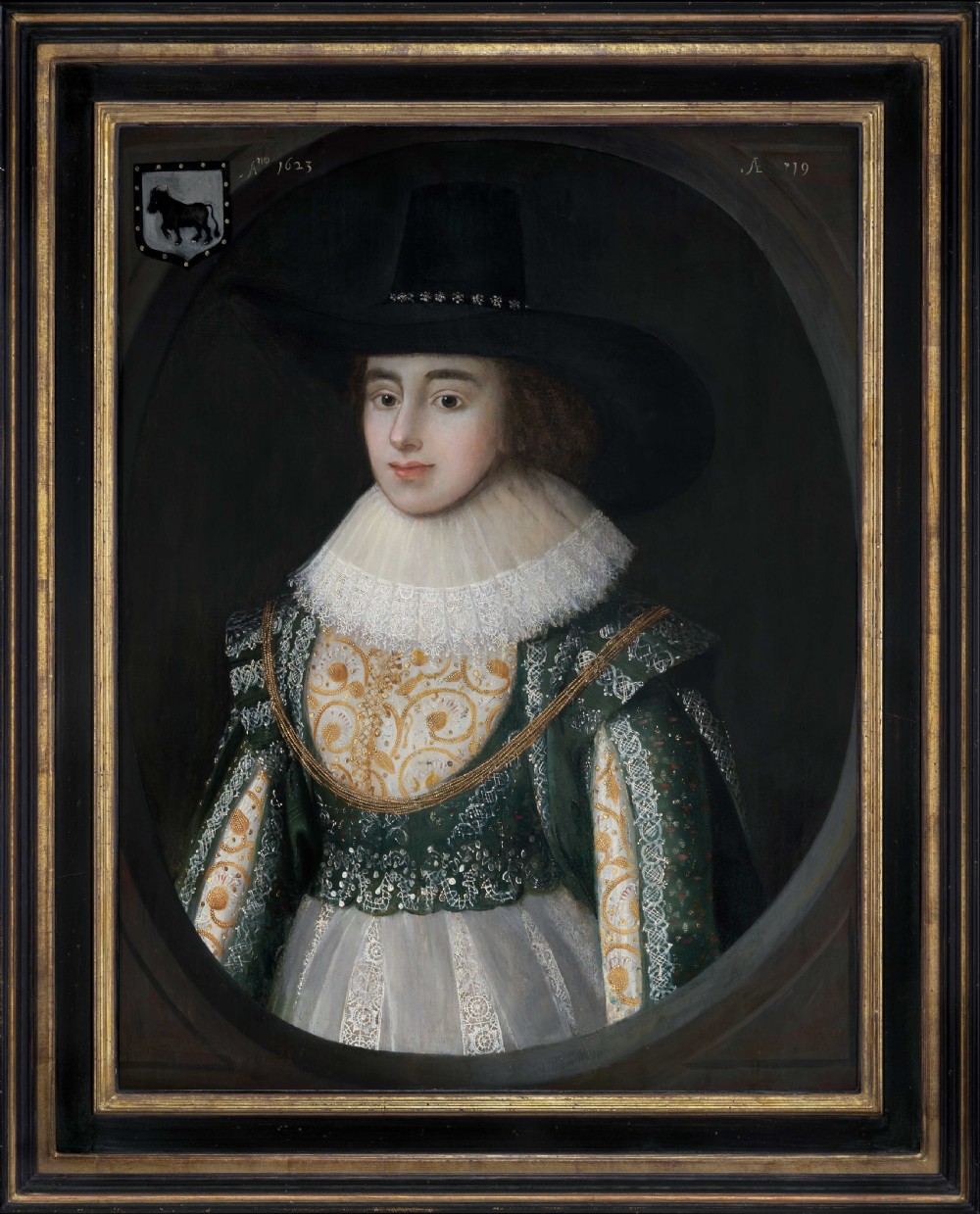 A seventeenth-century oil painting on panel featuring a woman in a wide-brimmed black hat, white lace ruff collar, and green embroidered gown within a feigned oval frame.