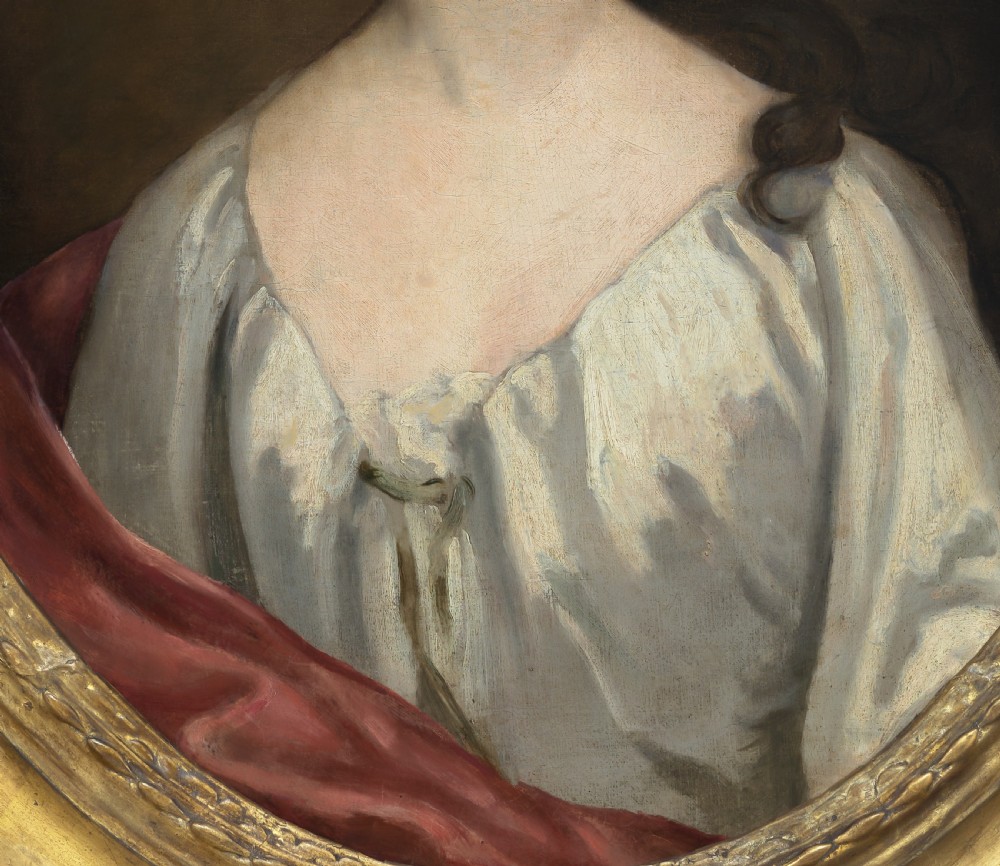 An eighteenth-century oval oil portrait depicting a young lady in a white gown and red mantle set inside a carved gilded frame. View IV