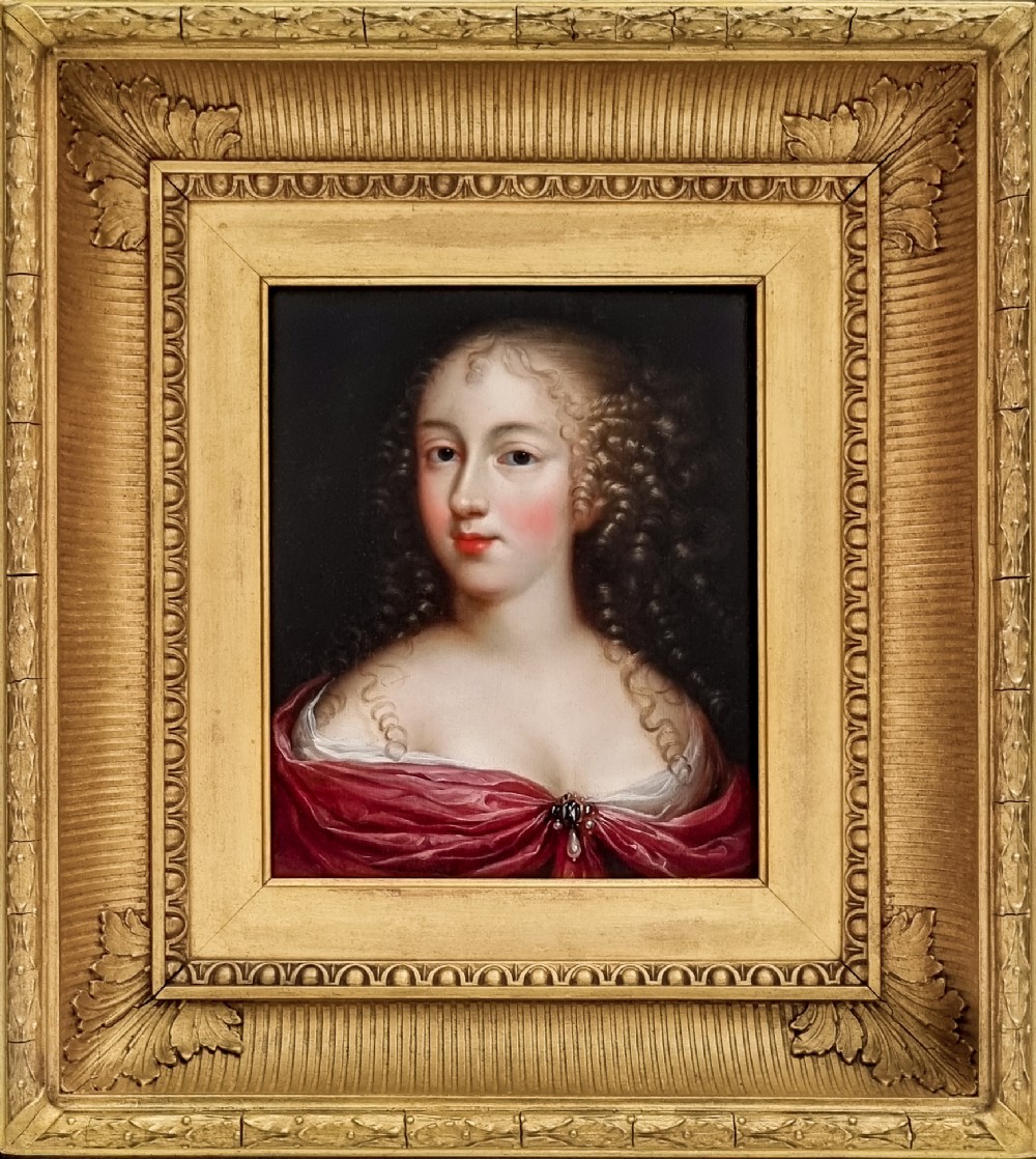 A seventeenth-century Baroque oil painting on wood panel depicting a portrait of a woman in a red gown inside an elaborate gilded frame.