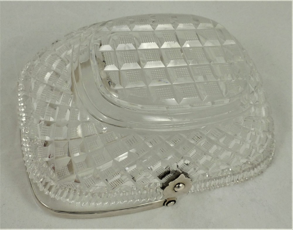 A 19th-century rectangular cut glass basket featuring diamond-patterned faceting and an arched silver swing handle attached to side mounts. View X