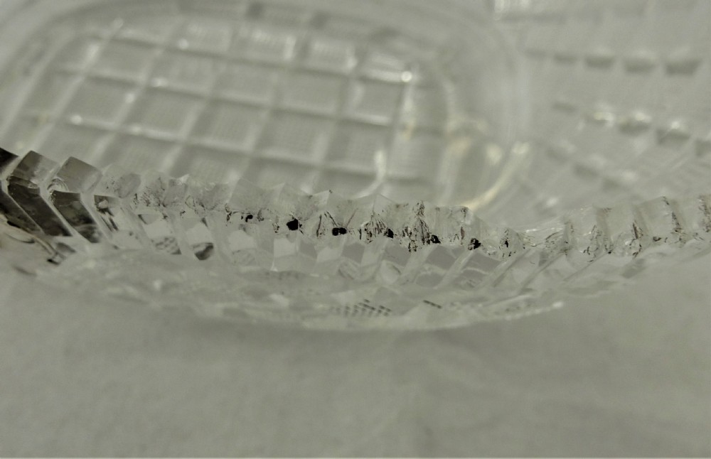 A 19th-century rectangular cut glass basket featuring diamond-patterned faceting and an arched silver swing handle attached to side mounts. View XIII
