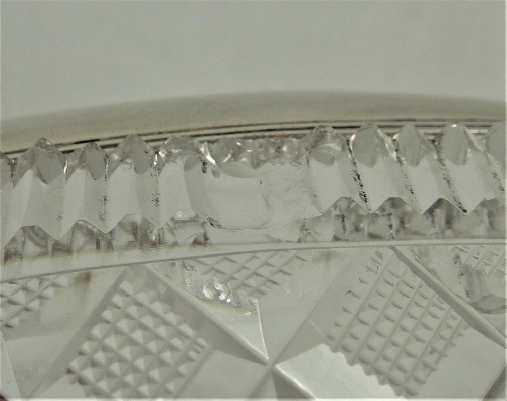 A 19th-century rectangular cut glass basket featuring diamond-patterned faceting and an arched silver swing handle attached to side mounts. View XV