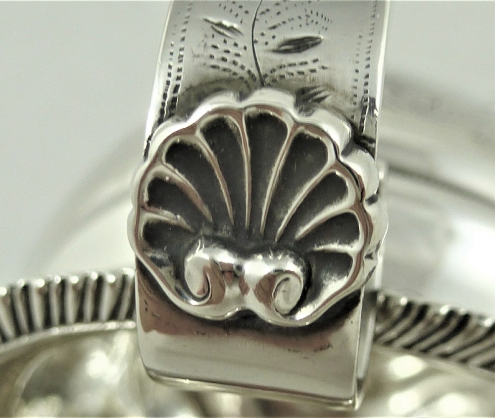 A Victorian sterling silver milk jug featuring gadrooned rim details, engraved geometric scrollwork, a shaped handle, and small ball feet. View XI