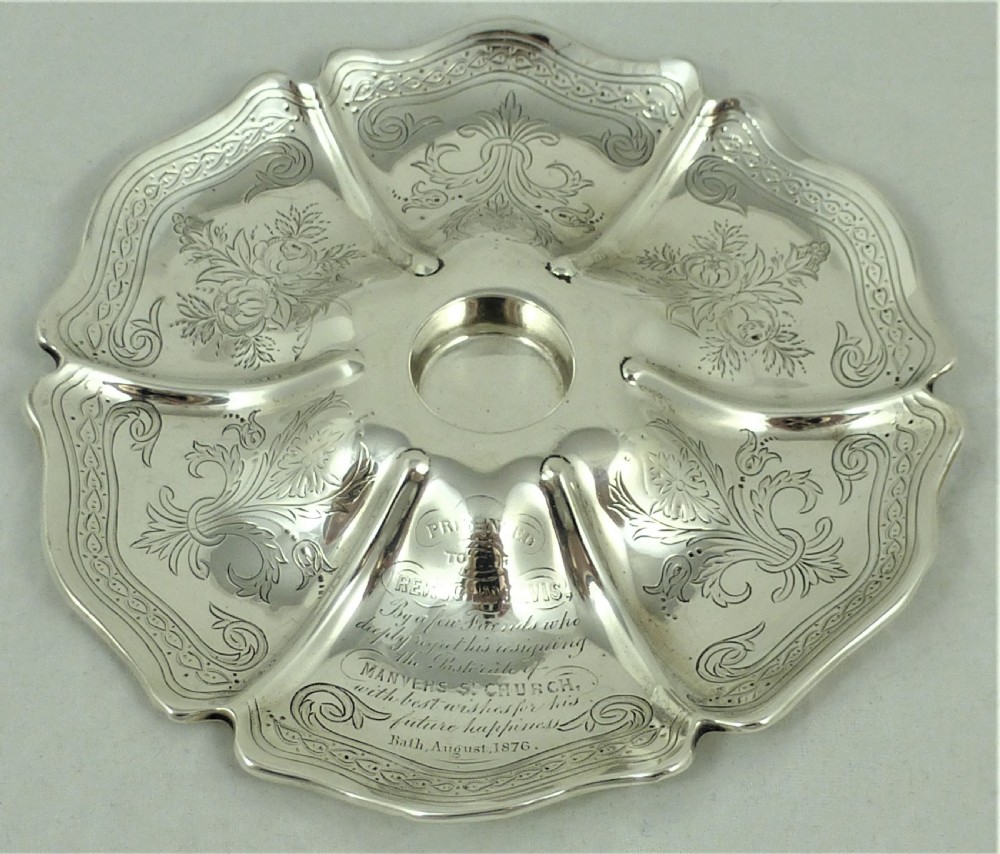 An engraved Victorian sterling silver inkstand featuring a scalloped rim tray and a central cut-glass inkwell with a silver hinged lid. View II