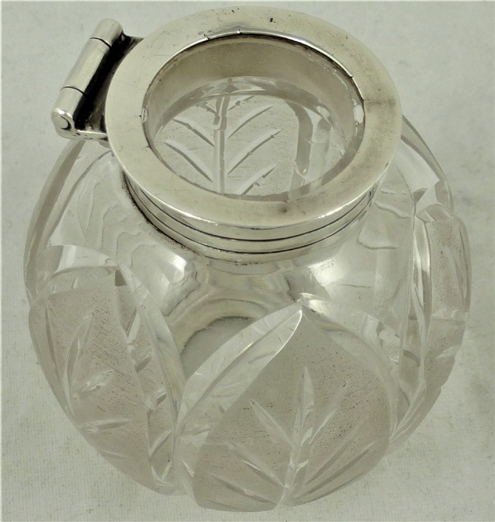 An engraved Victorian sterling silver inkstand featuring a scalloped rim tray and a central cut-glass inkwell with a silver hinged lid. View XII