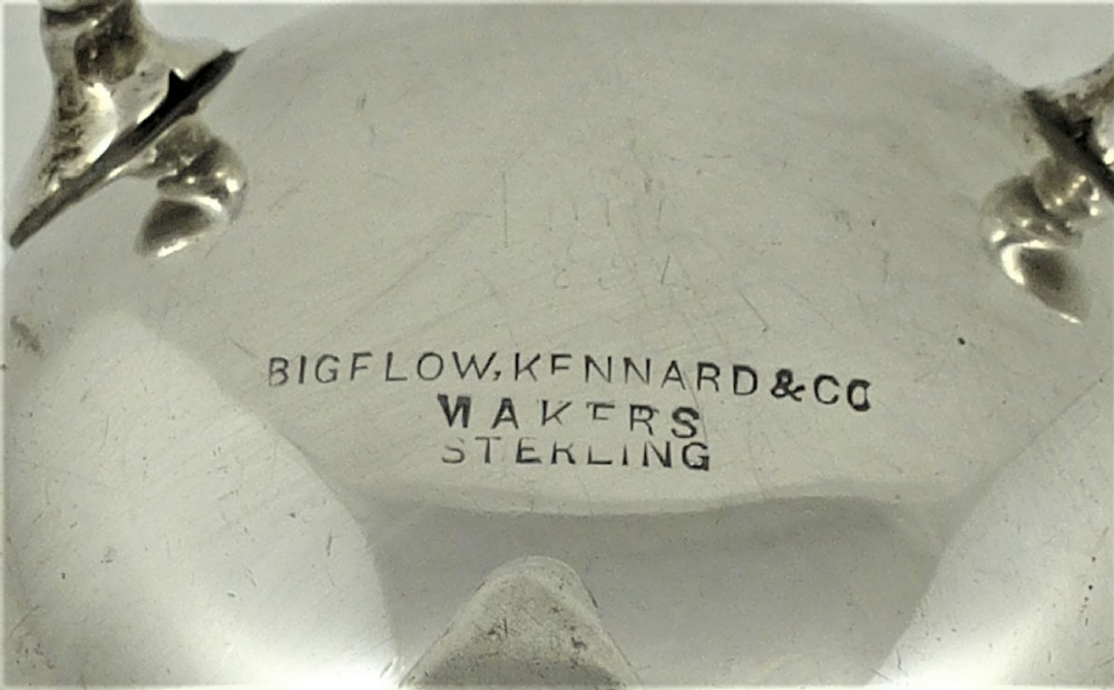 An American sterling silver milk jug featuring a baluster-shaped body, three cabriole legs with pad feet, a double-scroll handle, and a wavy scalloped rim. View II