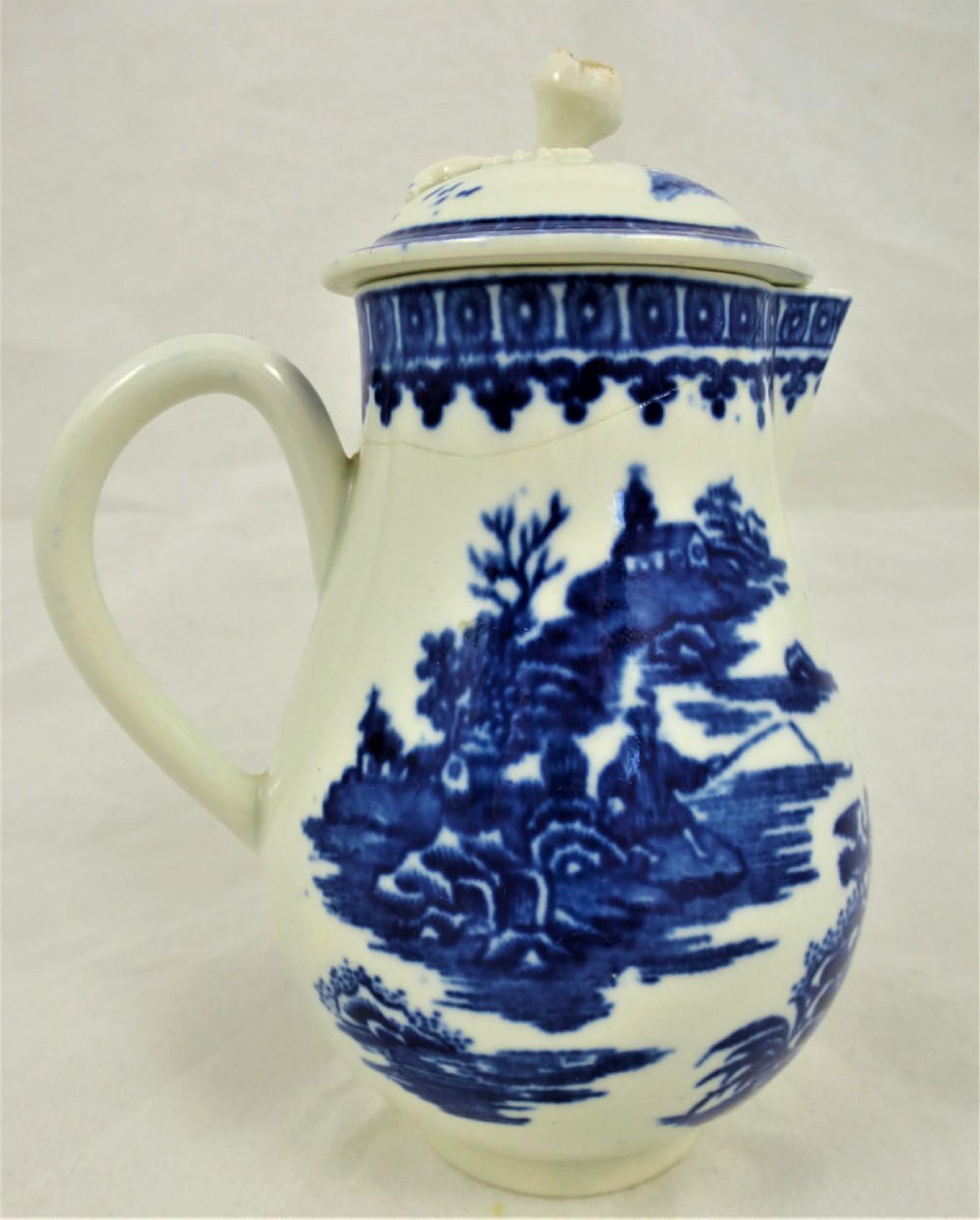 An 18th-century blue and white soft-paste porcelain sparrow beak cream jug with a floral finial lid and Chinoiserie scene. View III