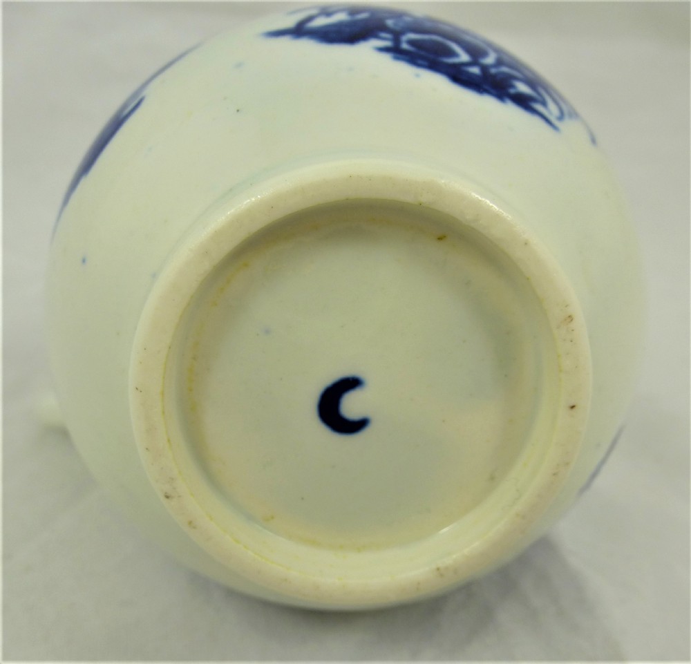 An 18th-century blue and white soft-paste porcelain sparrow beak cream jug with a floral finial lid and Chinoiserie scene. View VI