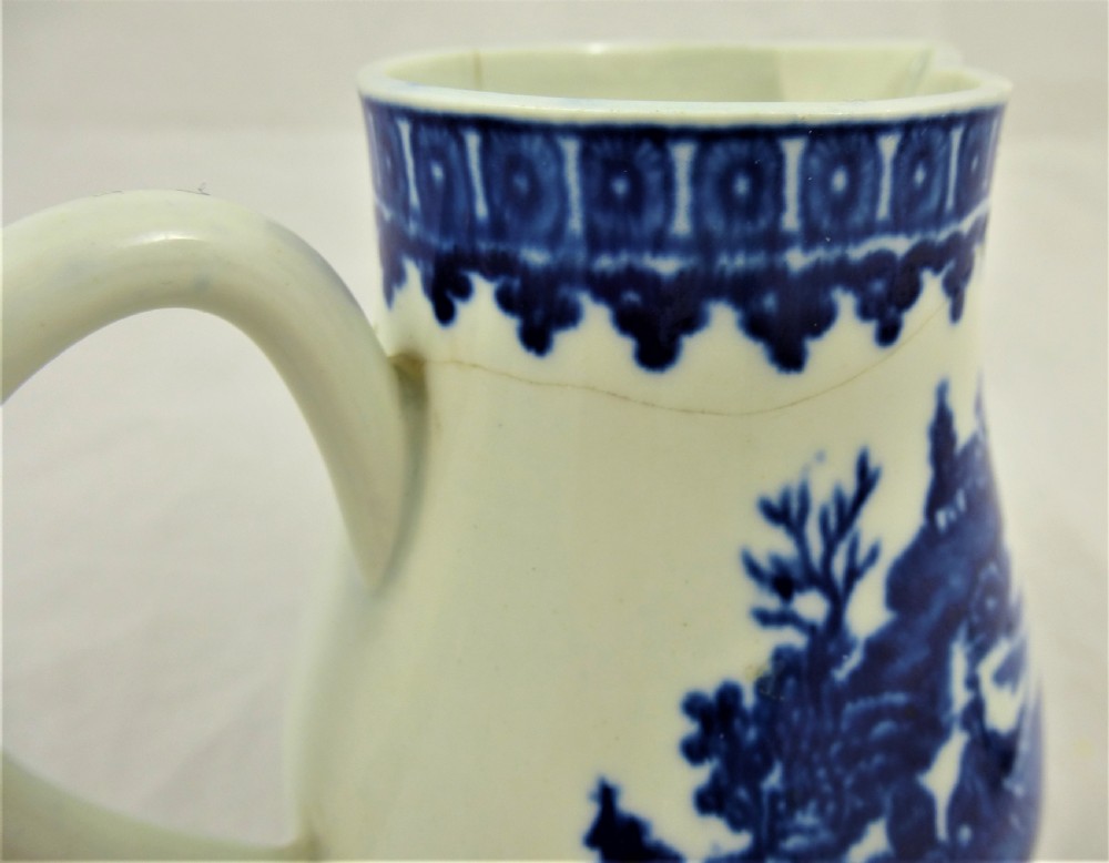 An 18th-century blue and white soft-paste porcelain sparrow beak cream jug with a floral finial lid and Chinoiserie scene. View X