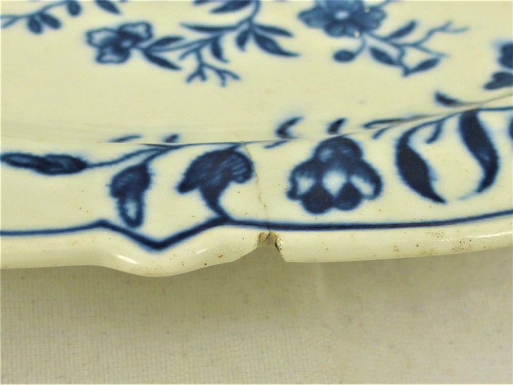 An eighteenth-century blue and white Worcester porcelain strawberry dish with pierced drainage holes resting on a matching scalloped stand. View V
