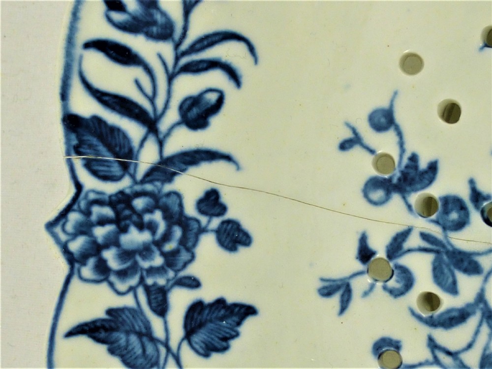 An eighteenth-century blue and white Worcester porcelain strawberry dish with pierced drainage holes resting on a matching scalloped stand. View IX