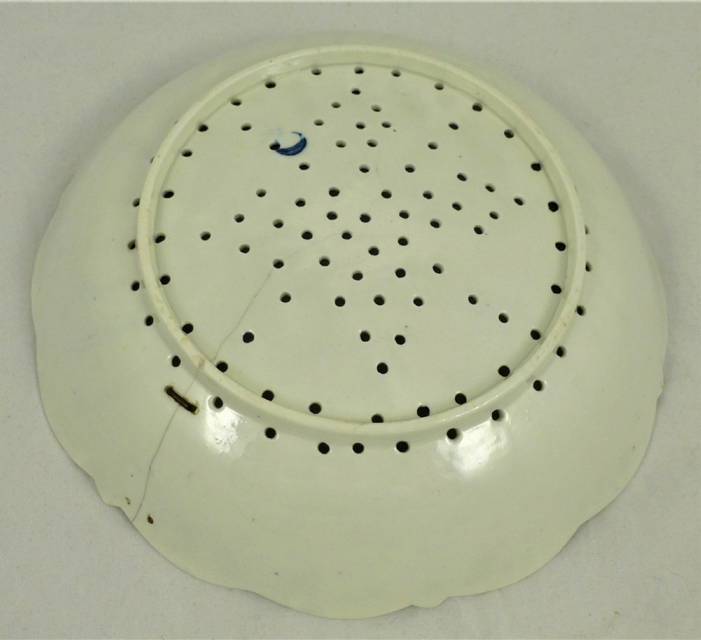 An eighteenth-century blue and white Worcester porcelain strawberry dish with pierced drainage holes resting on a matching scalloped stand. View X