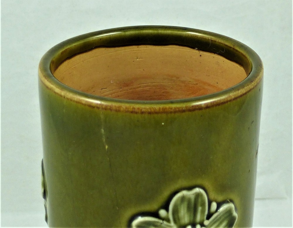 A Royal Doulton stoneware vase with a flared base, featuring a ribbed tan bottom section and a glazed olive green top rim adorned with an embossed flower motif. View V