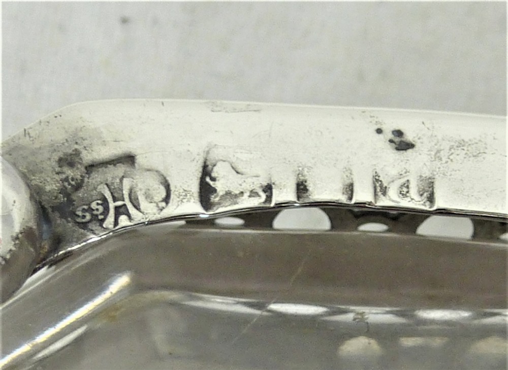A Victorian silver cruet stand featuring three pierced octagonal compartments, small ball feet, an angled central loop handle, and one clear glass insert. View VIII