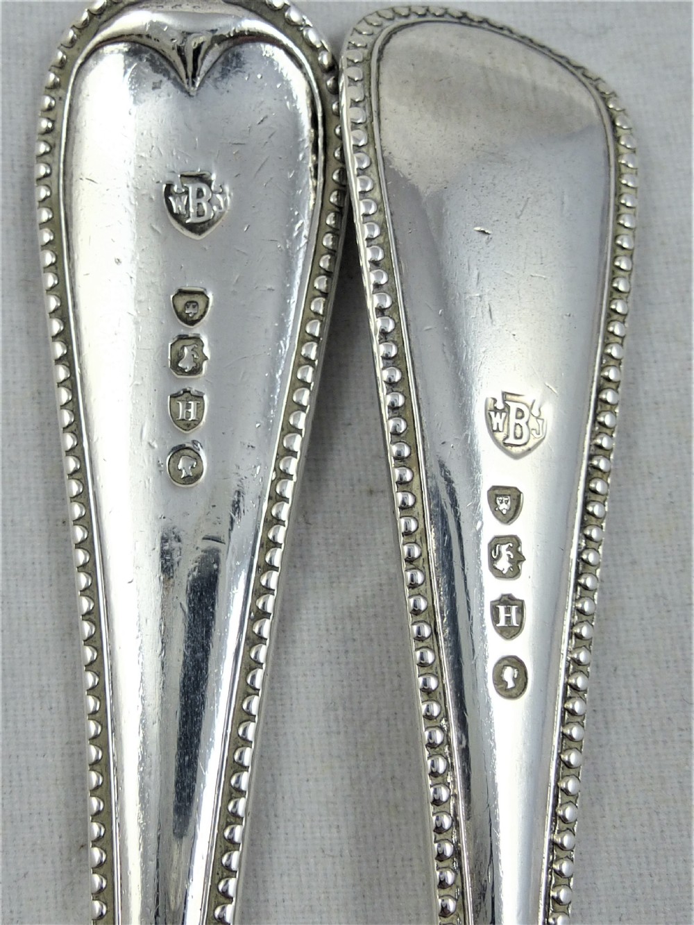 A matching Victorian sterling silver fork and spoon set featuring beaded borders along the handles. View III