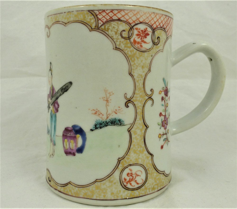 A cylindrical Chinese export porcelain mug featuring hand-painted figures and floral motifs within scalloped cartouche panels.