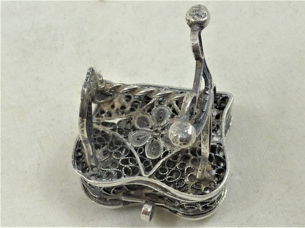 A 19th-century silver filigree miniature table featuring intricate openwork scrollwork and slender legs. View V