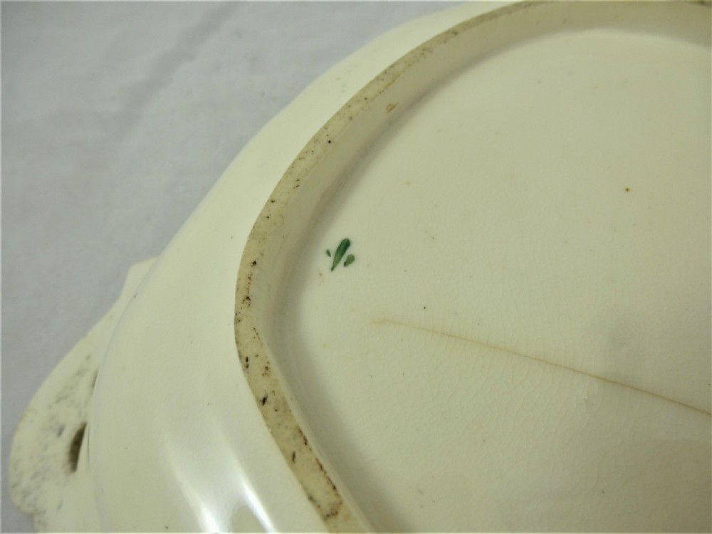 A five-piece English Rococo porcelain dessert service featuring cream-coloured shaped dishes hand-painted with green foliage, floral motifs, and gilt scalloped rims. View XXIX