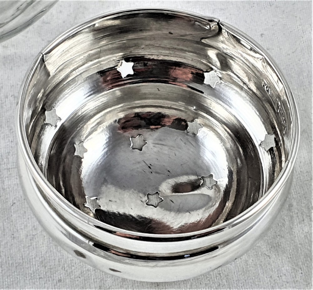 A tapered clear cut-glass sugar shaker featuring etched floral motifs and a domed, perforated silver cap. View XVII
