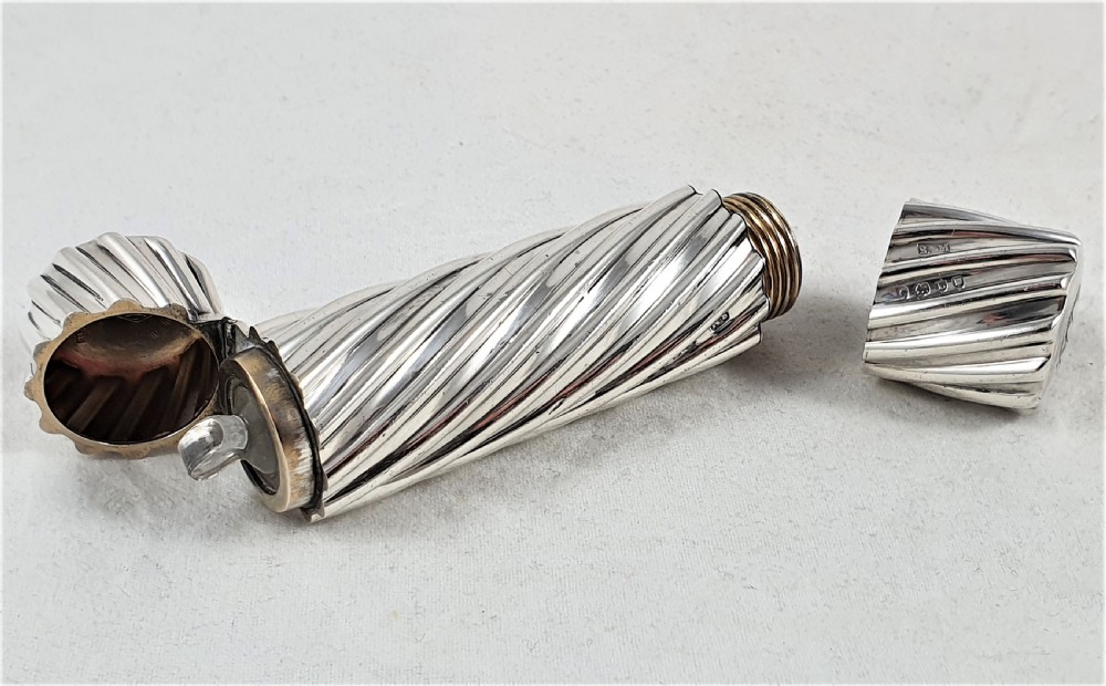 A Victorian sterling silver double-ended scent bottle with spiral fluted decoration, featuring a hinged lid with a glass stopper on one side and a detached screw cap on the other.