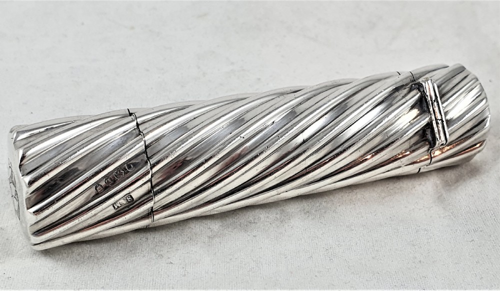 A Victorian sterling silver double-ended scent bottle with spiral fluted decoration, featuring a hinged lid with a glass stopper on one side and a detached screw cap on the other. View VII