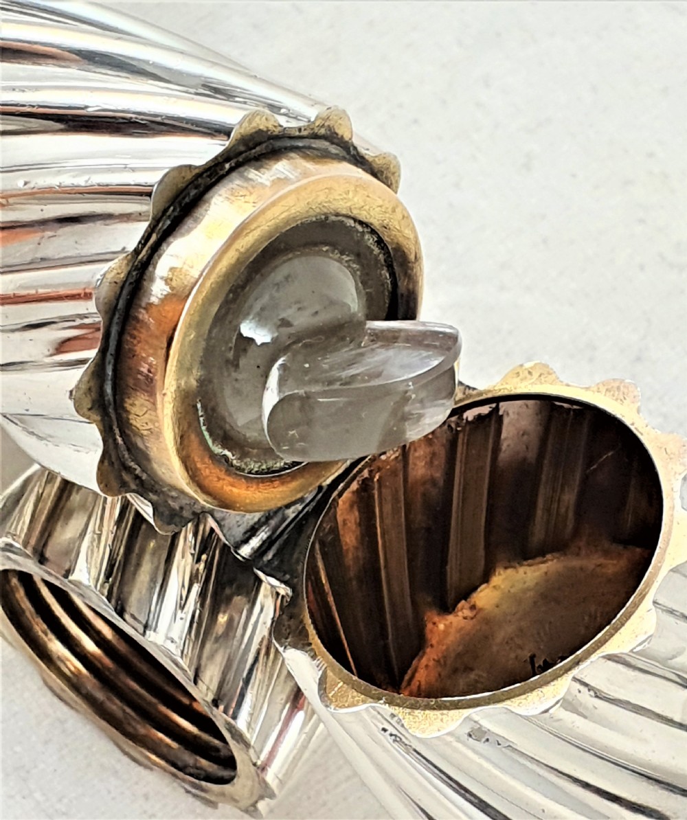 A Victorian sterling silver double-ended scent bottle with spiral fluted decoration, featuring a hinged lid with a glass stopper on one side and a detached screw cap on the other. View XI