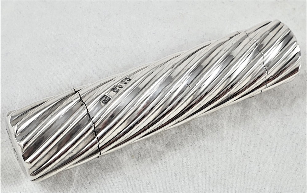 A Victorian sterling silver double-ended scent bottle with spiral fluted decoration, featuring a hinged lid with a glass stopper on one side and a detached screw cap on the other. View XIII
