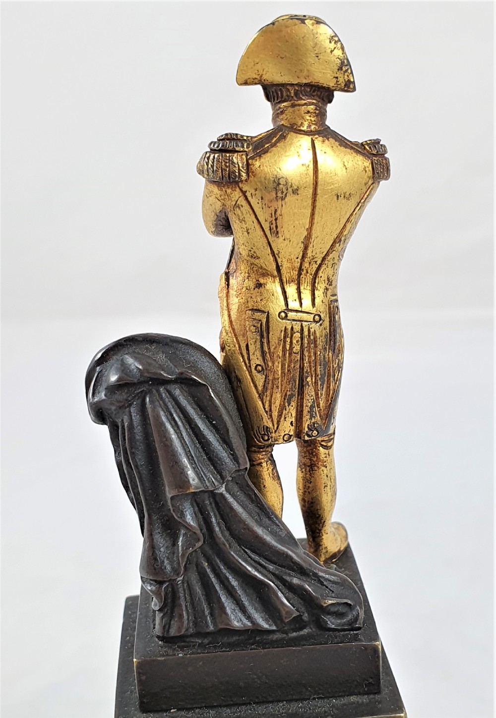 A late nineteenth-century French bronze statuette depicting Napoleon Bonaparte with arms crossed standing on a dark pedestal featuring a gilt eagle motif. View IX
