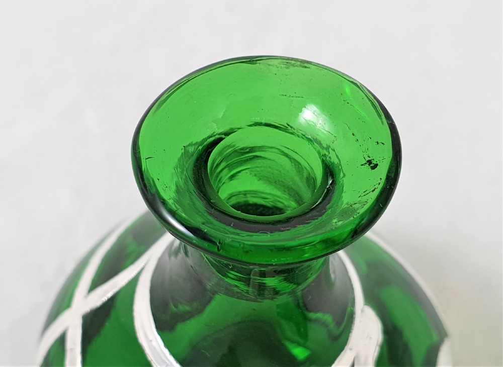 An Art Nouveau green glass scent bottle featuring silver overlay scrollwork and a fitted dark stopper. View VII
