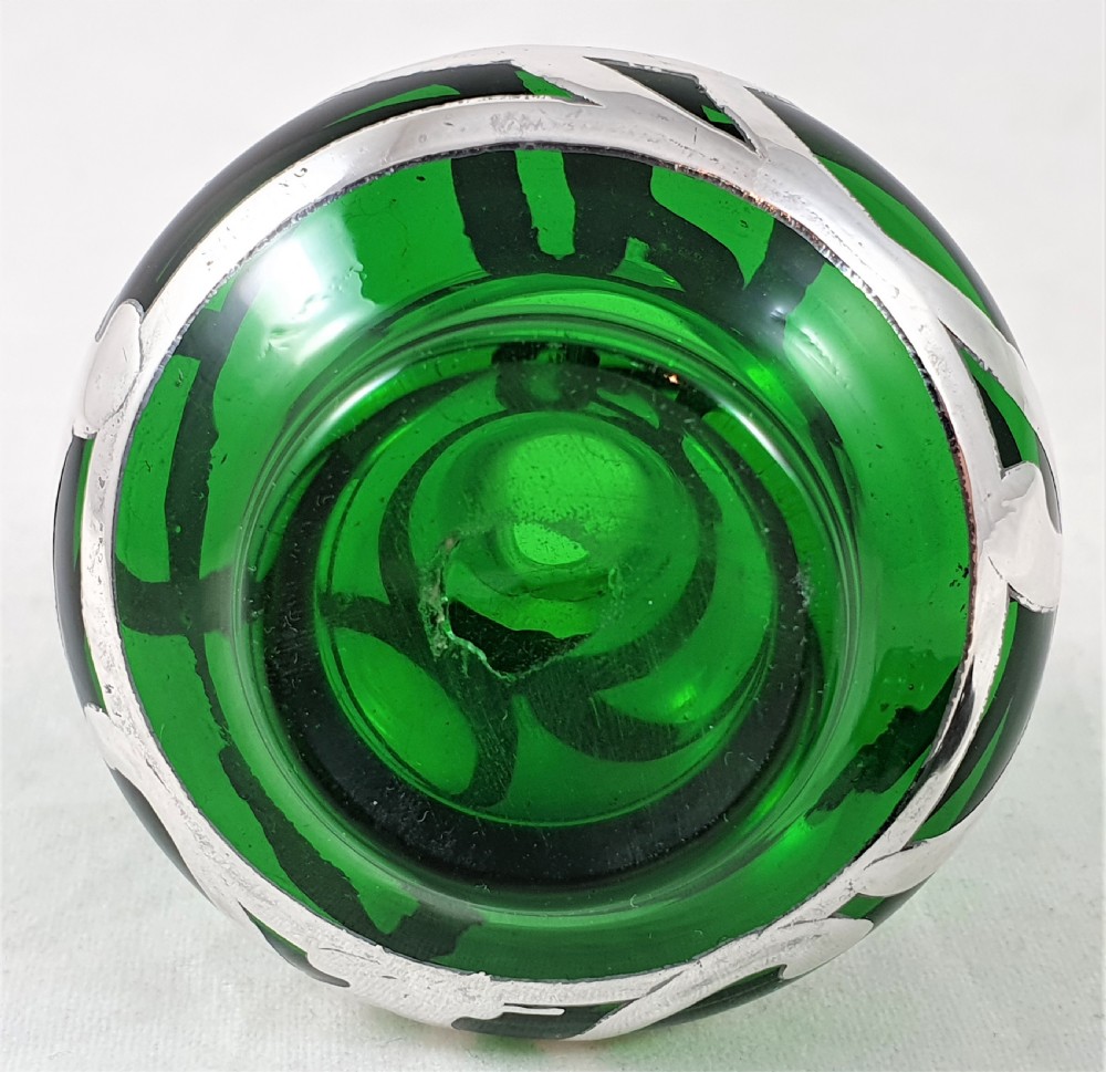 An Art Nouveau green glass scent bottle featuring silver overlay scrollwork and a fitted dark stopper. View VIII
