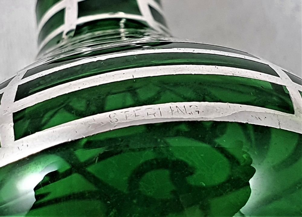 An emerald green glass perfume bottle featuring silver overlay in geometric and linear patterns with a matching silver-covered globe stopper. View IX